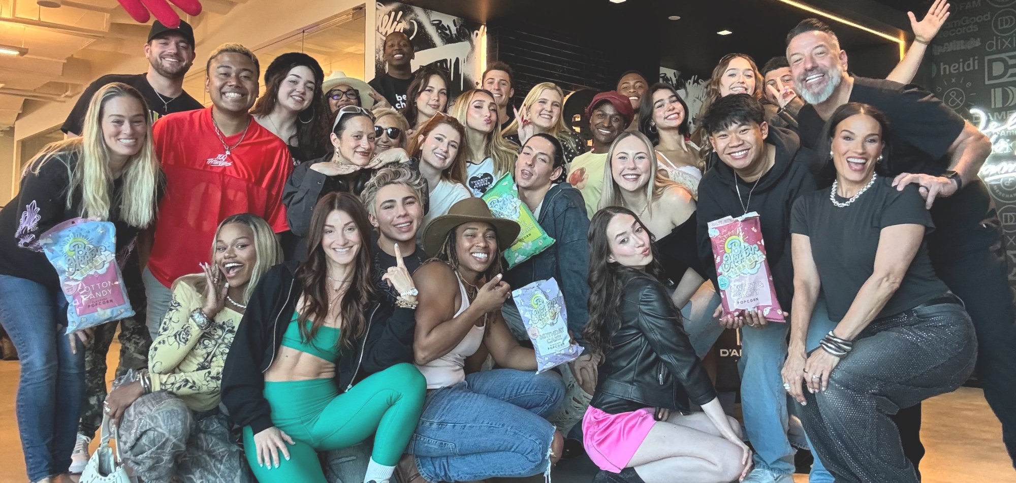 Marc and Heidi D'Amelio with a large group of creators, everyone holding Be Happy Popcorn
