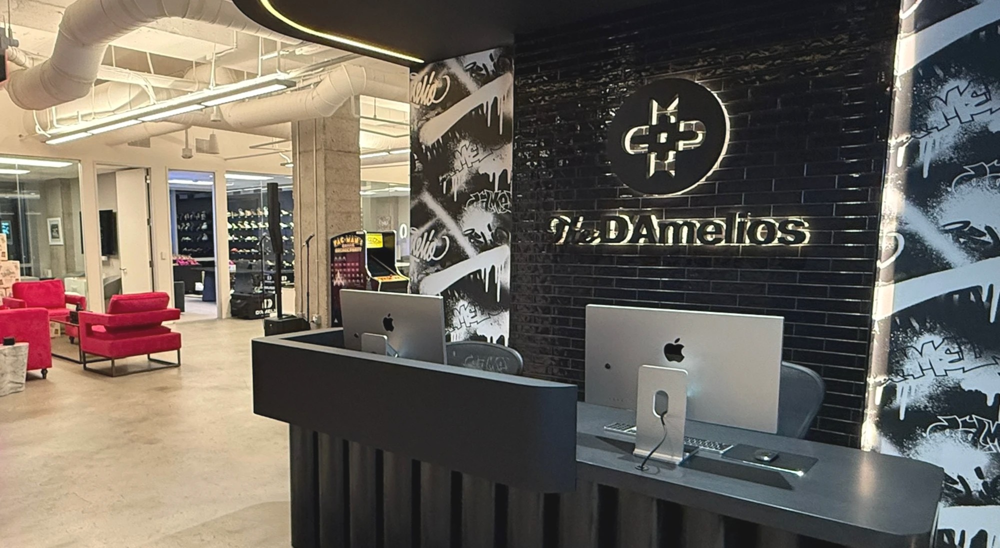The reception desk at the D'Amelio office, The D'Amelios sign glowing on black brick