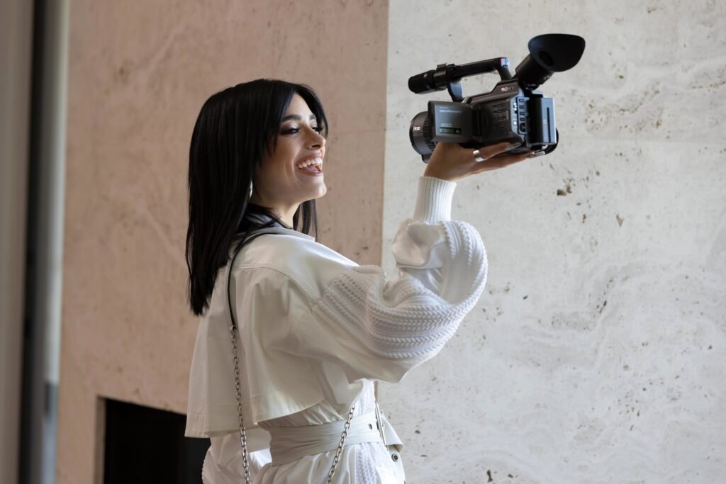 Dixie D’Amelio filming with a camcorder on set